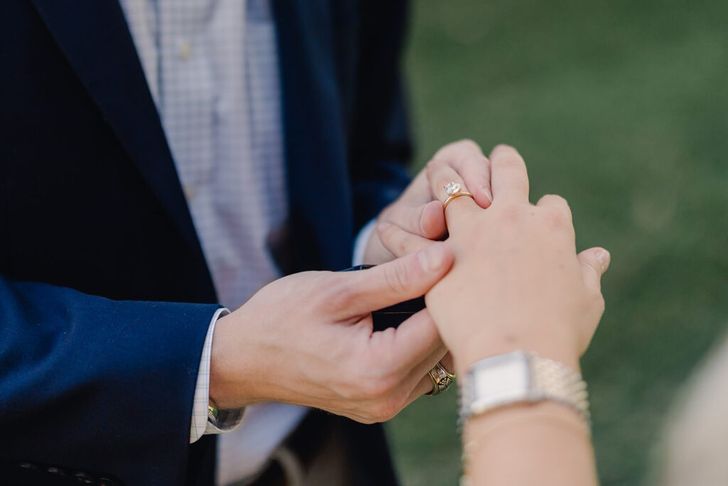 Sliding engagement ring on fiancé's hand. 