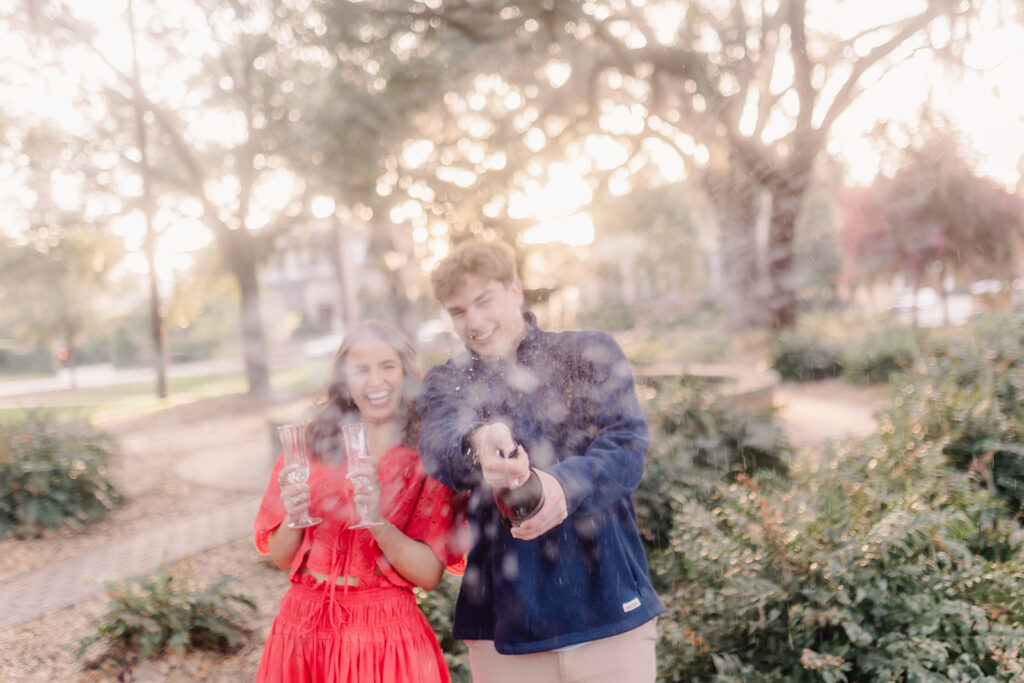 Couple celebrating with champagne after a surprise proposal. 