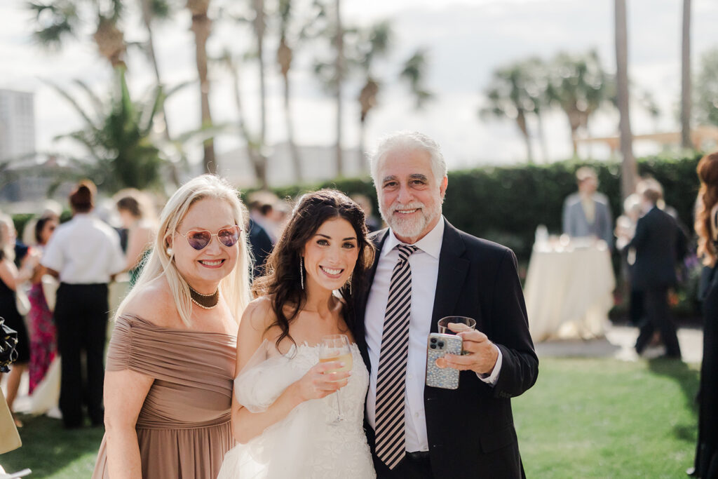 Wedding First Look - Bride in photograph with family at cocktail hour.
