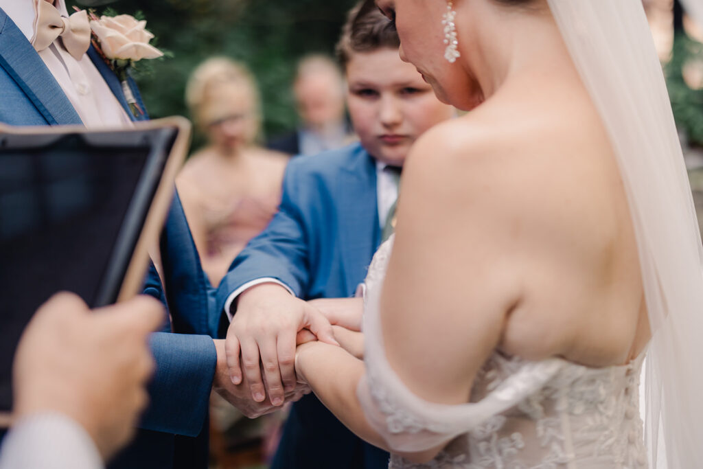 Groom, bride and bride's son make commitments to each other during wedding ceremony.