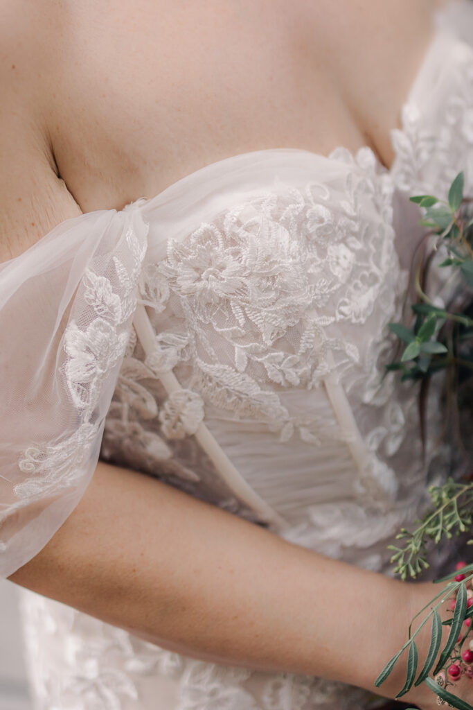 details on bride's off-the-shoulder dress