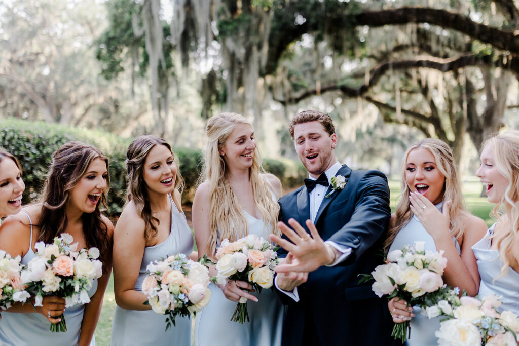 Wedding First Look - Groom in candid photo with bridesmaids. 